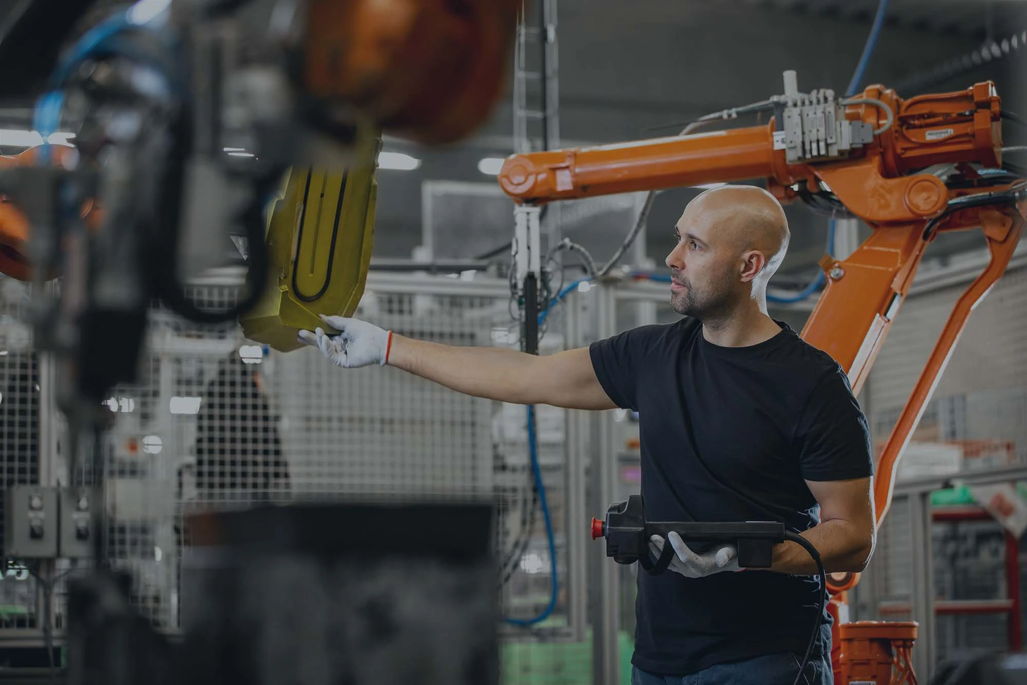 automotive industry worker inspecting robots